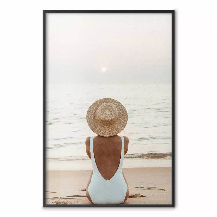 Strandrust - vrouw zittend op het zand met de zonsondergang op de achtergrond