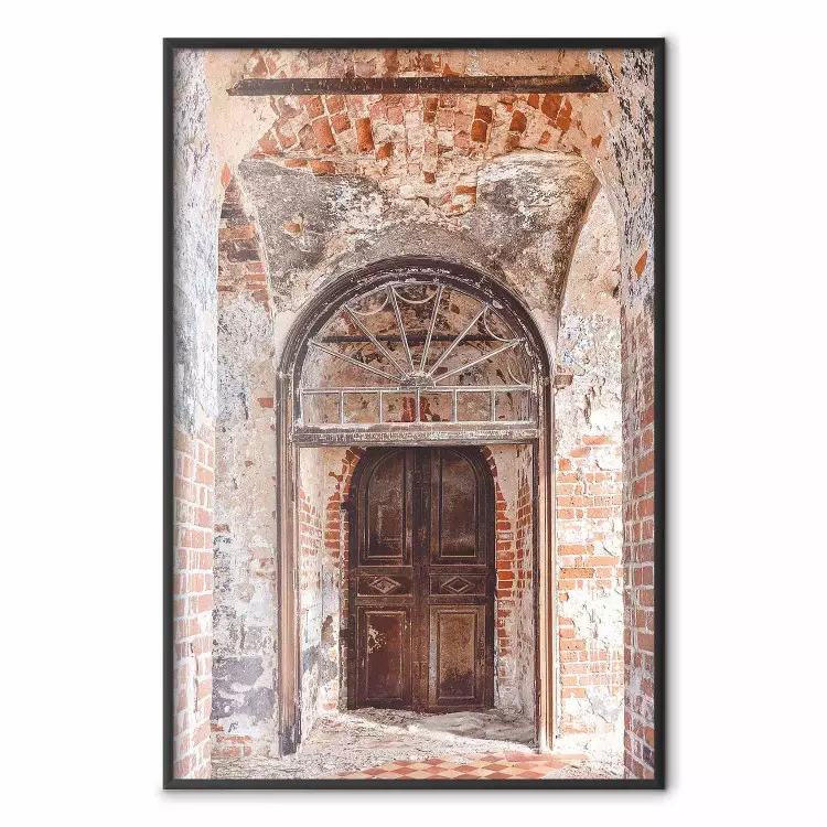 Een sierlijke boog - een houten deur in een oud bakstenen gebouw